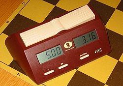 Photo shows a digital chess clock. There are two clocks, one on each side and a button on top of each stops that clock and starts the other
